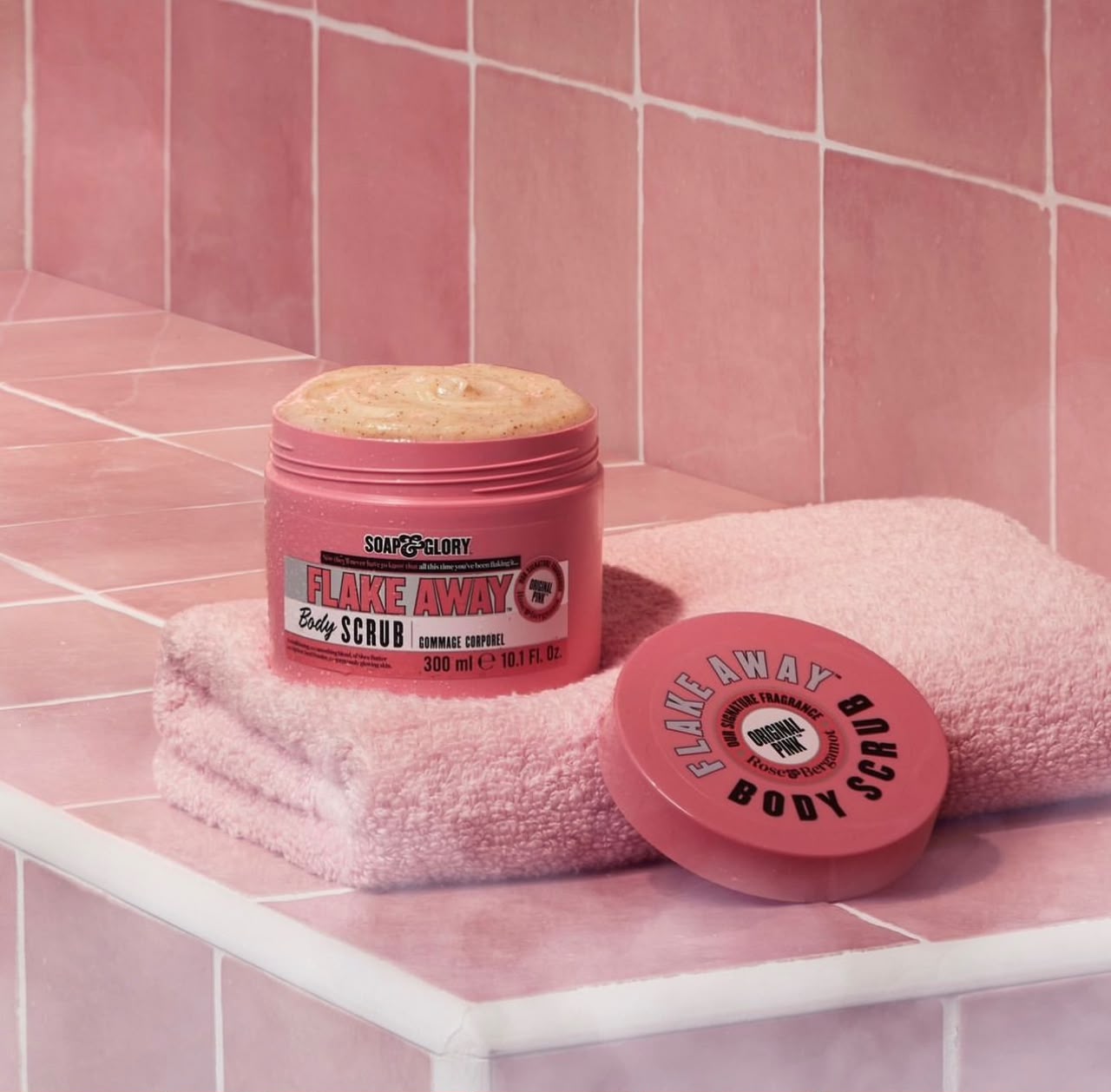 Soap & Glory Flake Away Body Scrub 300ml pink tub on a folded towel